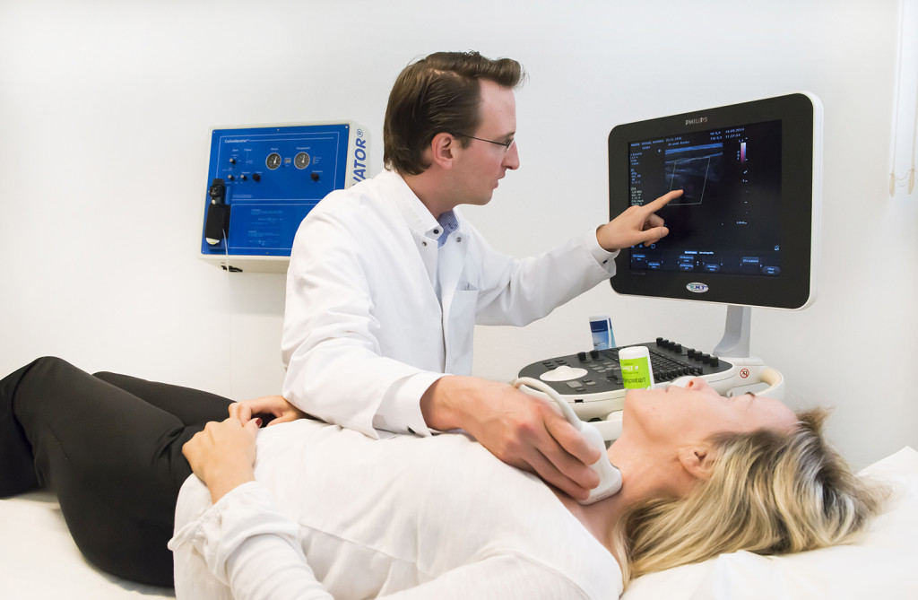 Arzt erläutert einen Ultraschallbefund am Monitor