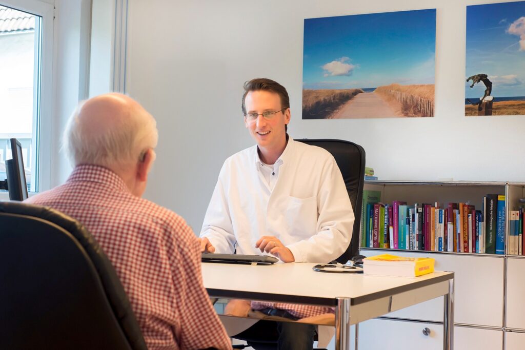 Arzt im Gespräch mit einem Patienten im Sprechzimmer